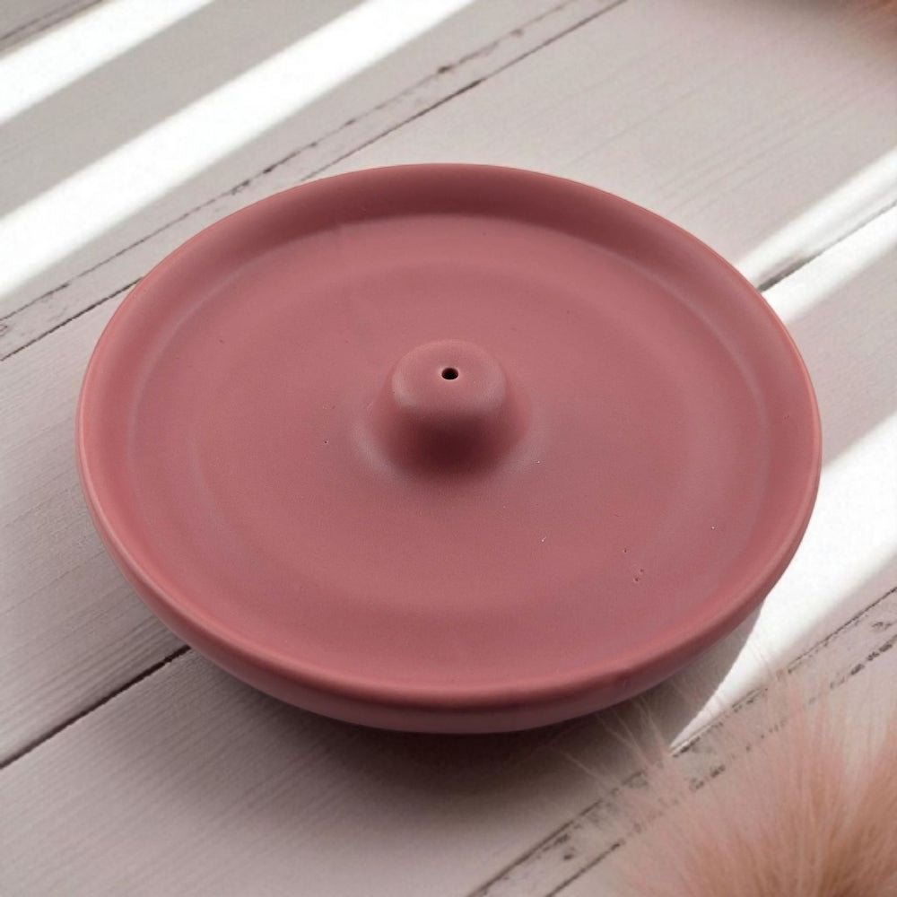 Pink ceramic mess free incense burner on a light wooden surface