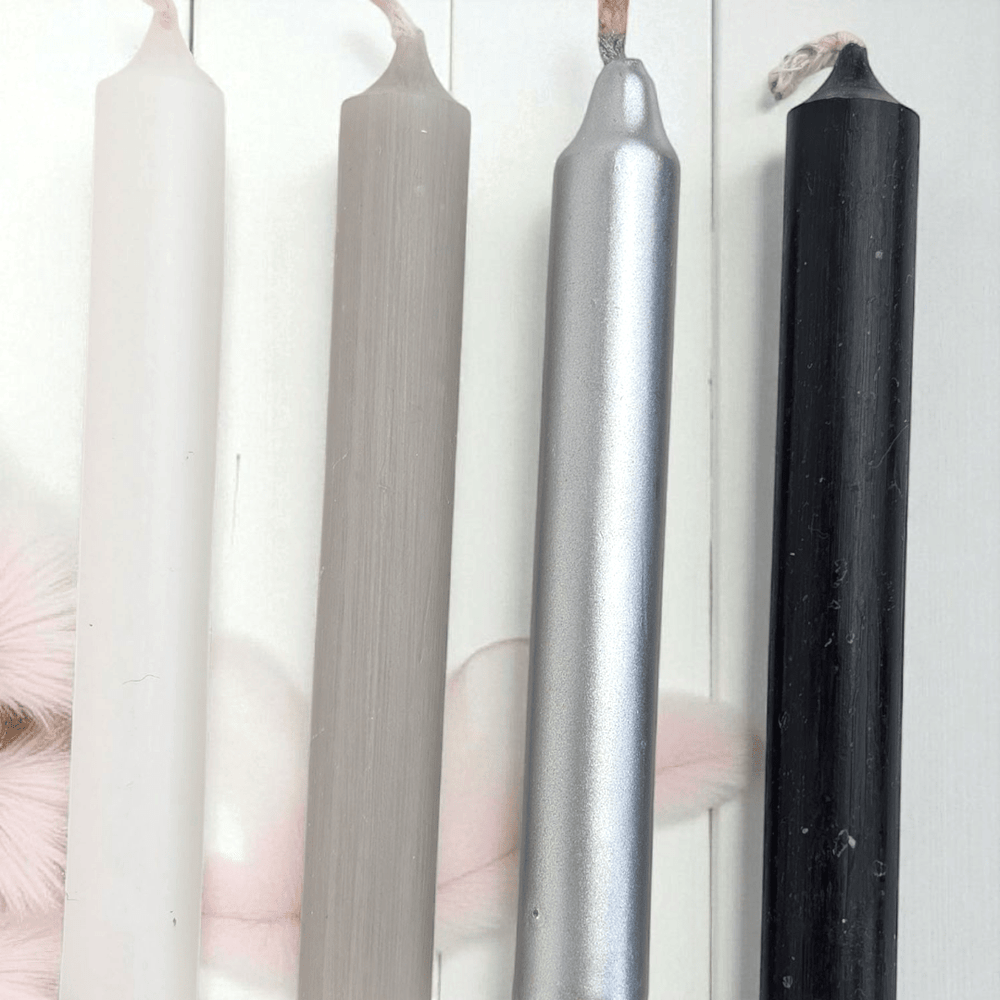Four candles of different colors (white, gray, silver, black) on a white background. Shop in-store at our crystal shop in Barrie or online 24/7