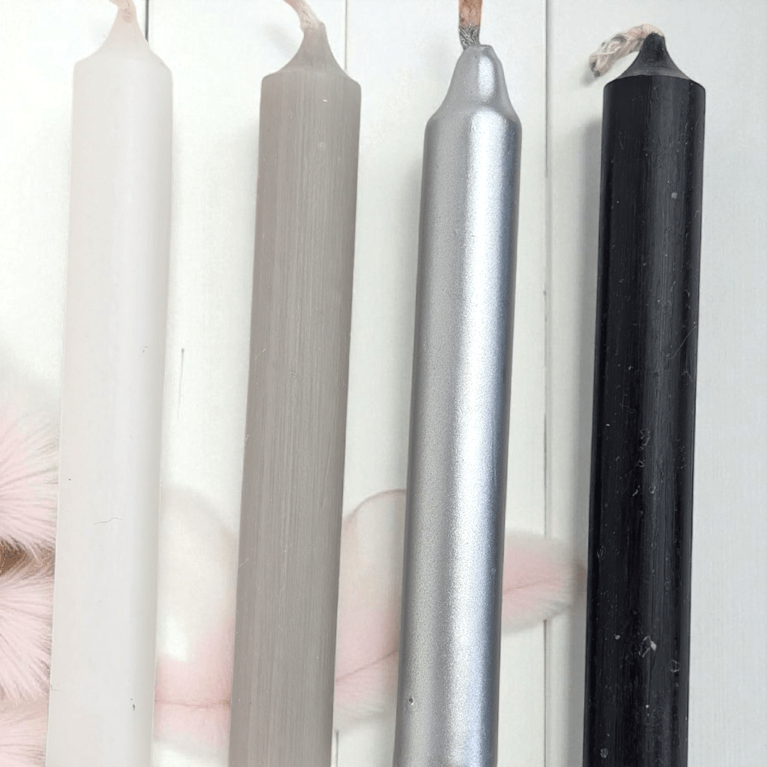 Four candles of different colors (white, gray, silver, black) on a white background. Shop in-store at our crystal shop in Barrie or online 24/7