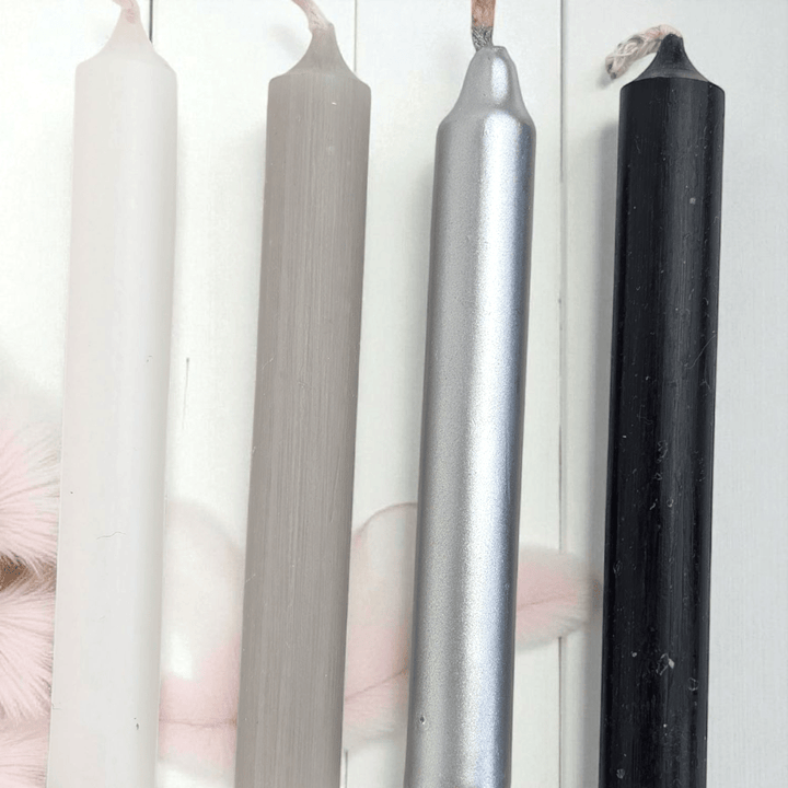 Four candles of different colors (white, gray, silver, black) on a white background. Shop in-store at our crystal shop in Barrie or online 24/7