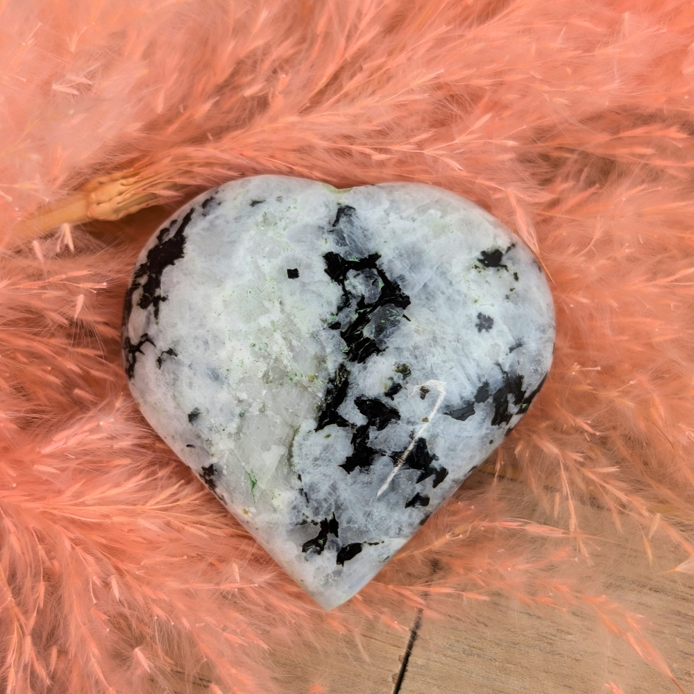 Hand holding Rainbow Moonstone Heart for meditation and energy work