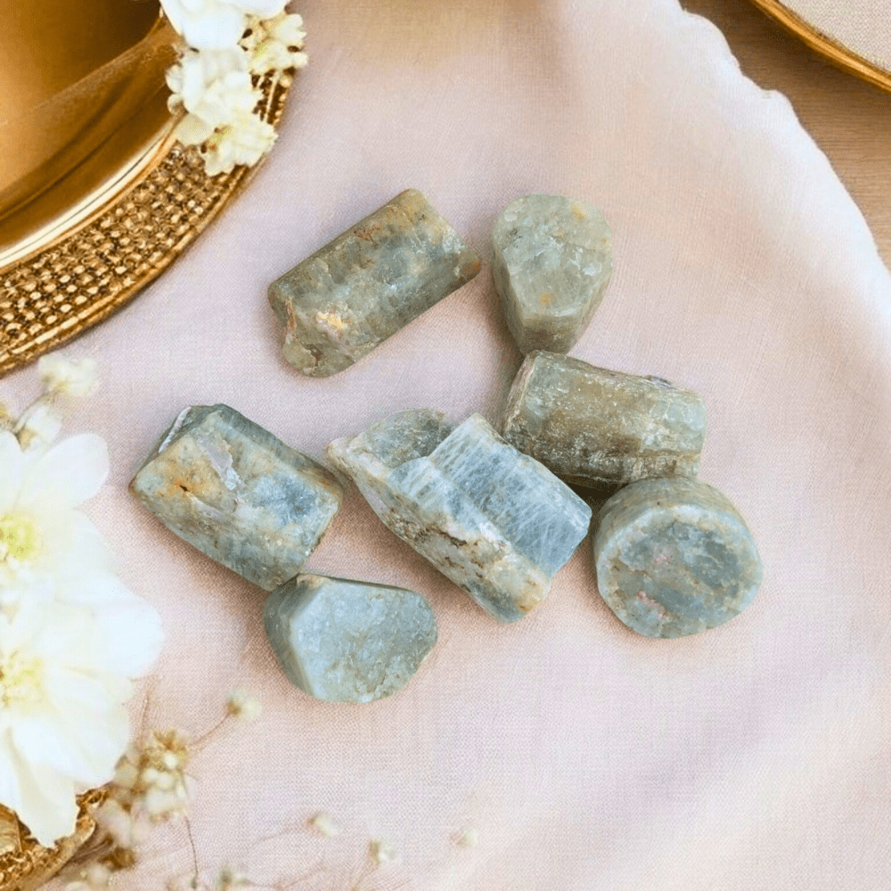 Raw aquamarine stones with pale blue hues and natural inclusions.