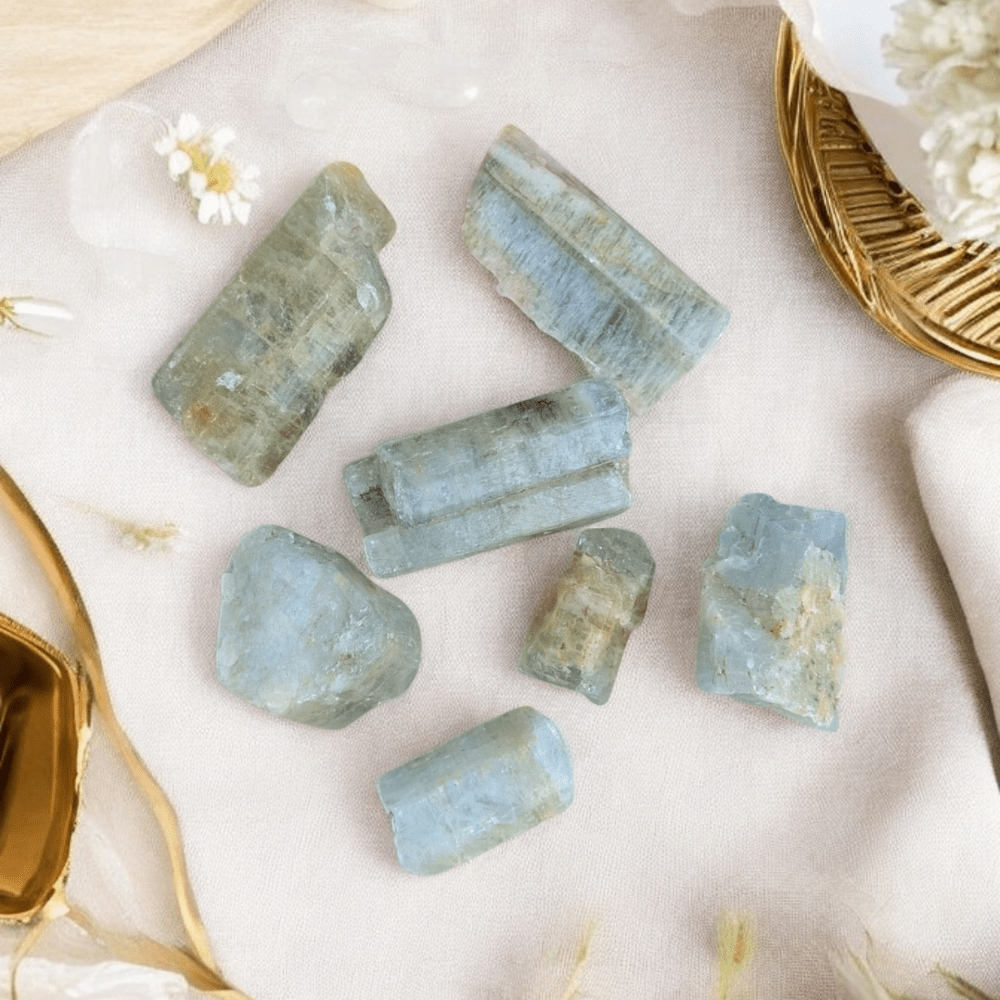 Small-Medium aquamarine pieces arranged on a soft fabric surface.