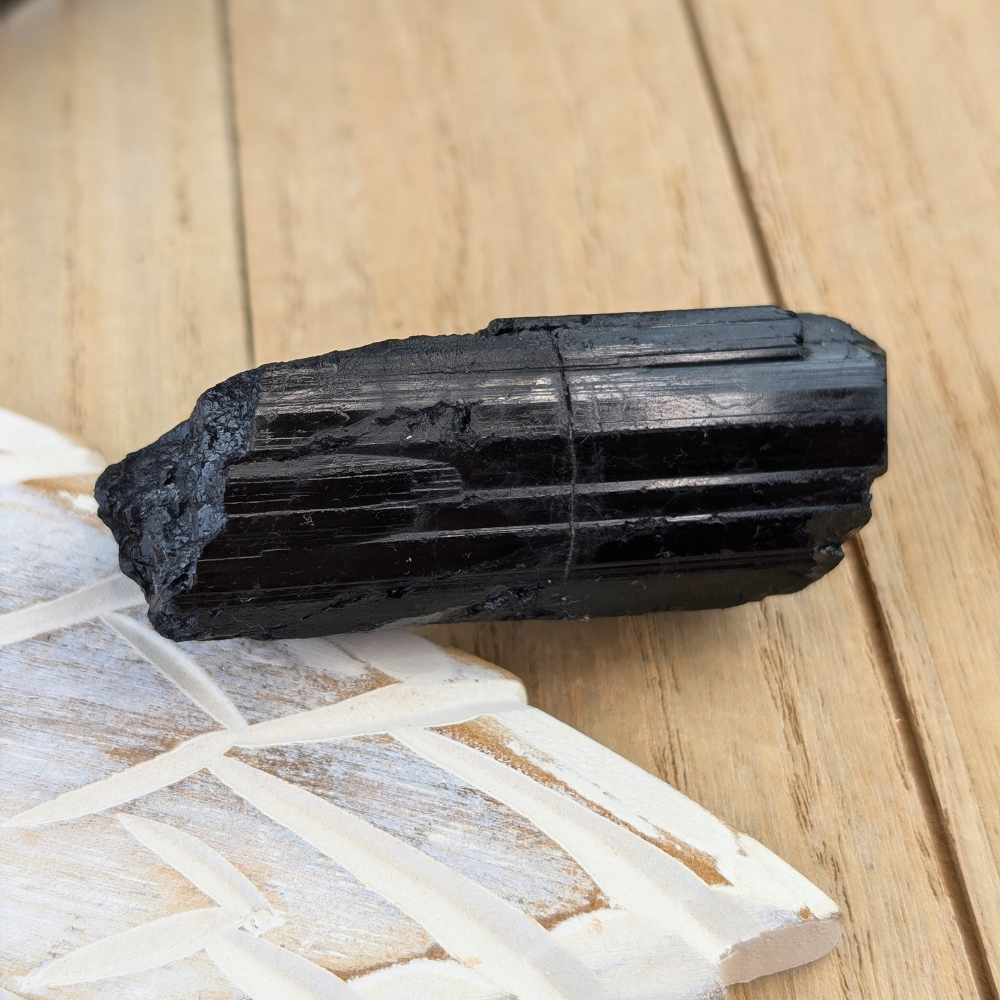 Raw Black Tourmaline Crystal Side View - A side view of the raw Black Tourmaline crystal, showcasing its vertical striations and natural texture for grounding and protection.