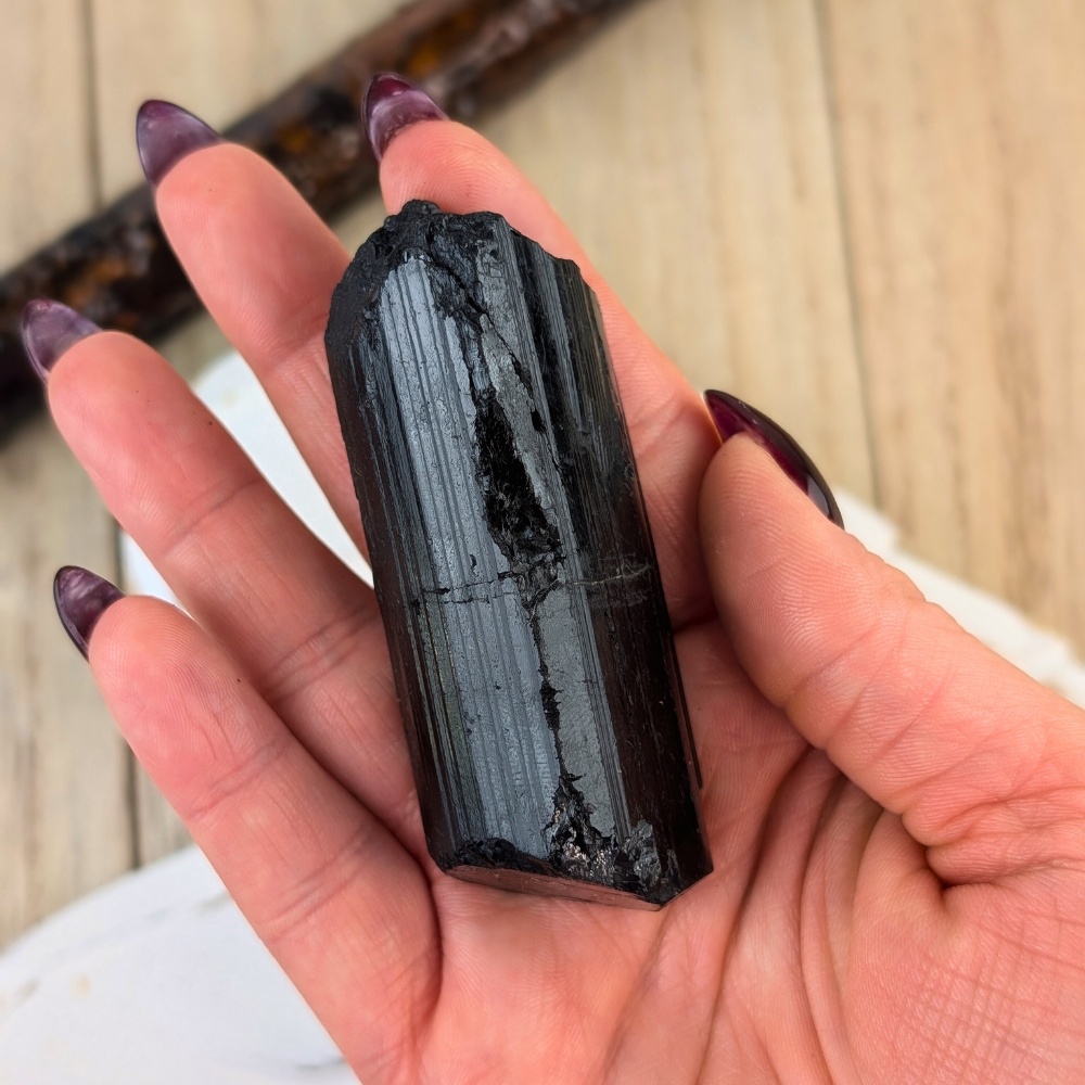 Black Tourmaline Crystal for Grounding - A handheld Black Tourmaline crystal, demonstrating its size and use for grounding practices during meditation.