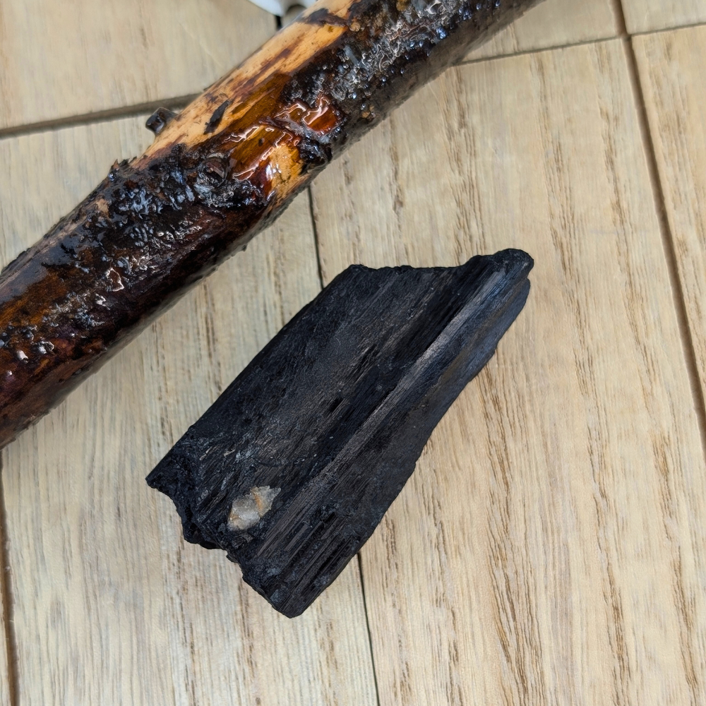 Raw Black Tourmaline Crystal Side View - A side view of a raw Black Tourmaline crystal, showing its natural texture and vertical striations.