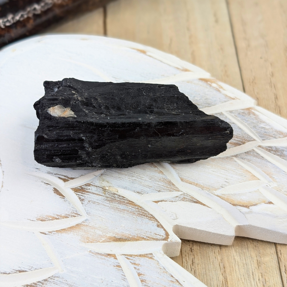 Raw Black Tourmaline Crystal Side View - A side view of a raw Black Tourmaline crystal, showing its natural texture and vertical striations.