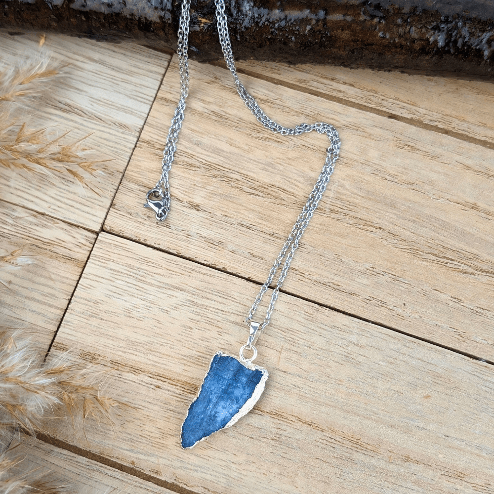 Raw Kyanite Necklace featuring a silver-tone chain on a wooden background.