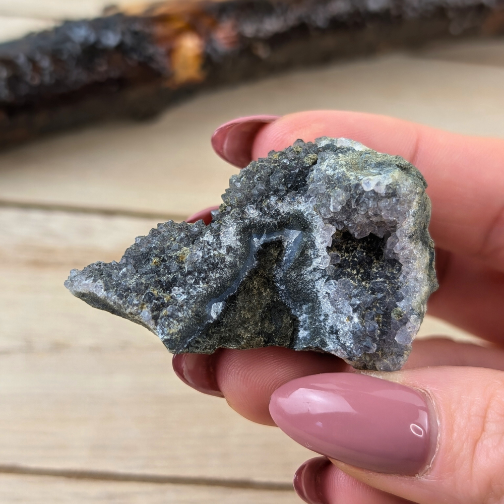 Close-up of Raw Rainbow Amethyst held in hand for scale