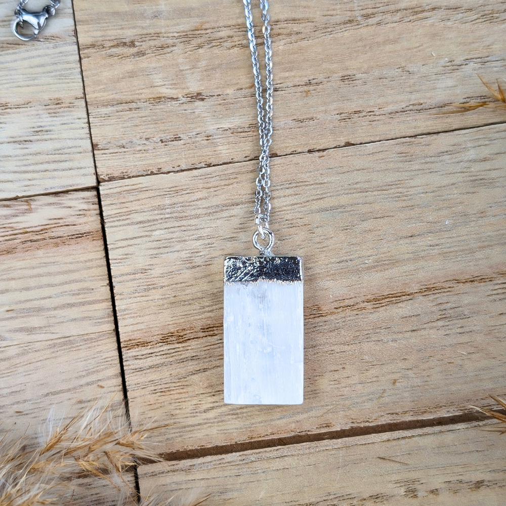 Silver raw selenite necklace on natural backdrop