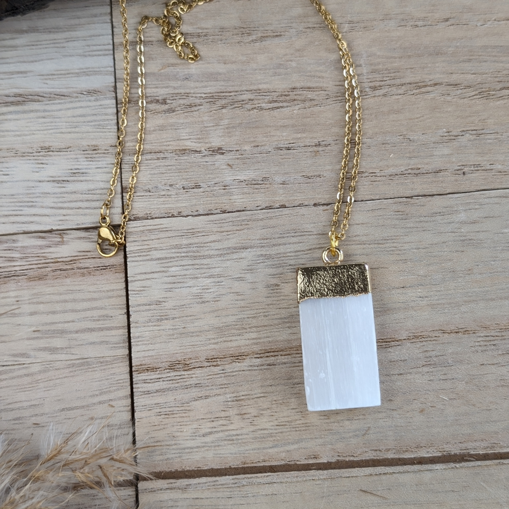 minimalist raw selenite necklace displayed on wood