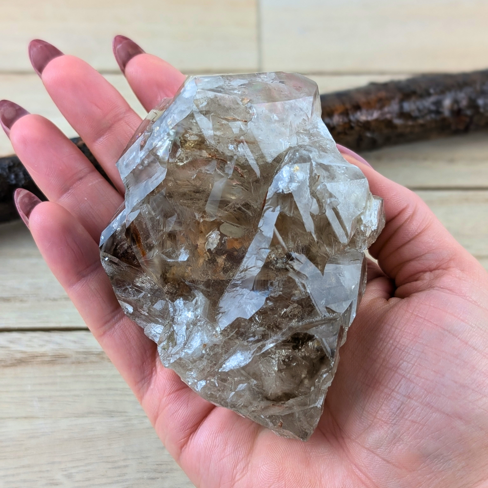 Raw Smoky Quartz cluster crystal held in hand for scale.