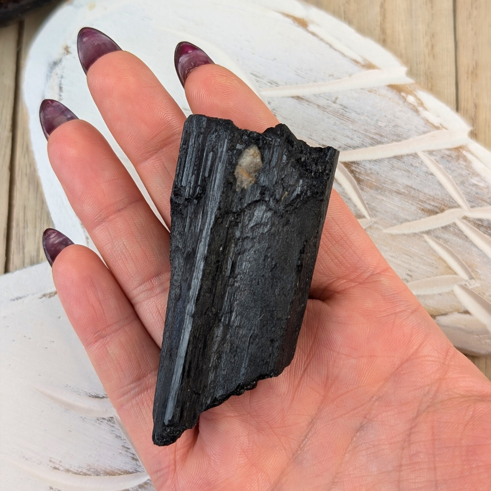 Raw Black Tourmaline with Vertical Striations - A raw Black Tourmaline crystal displaying its distinct vertical striations, known for its ability to absorb negative energy and offer protection.