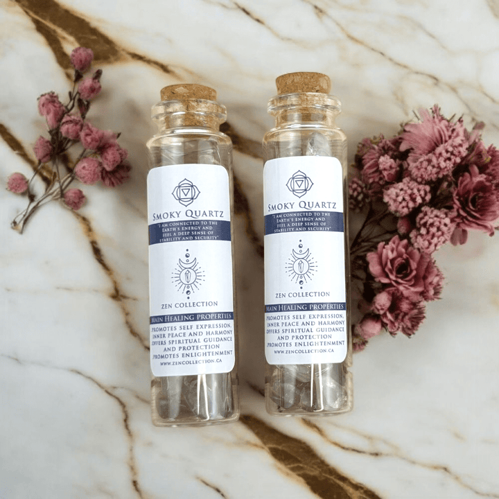 Two Smoky Quartz bottles on a marble surface with flowers.