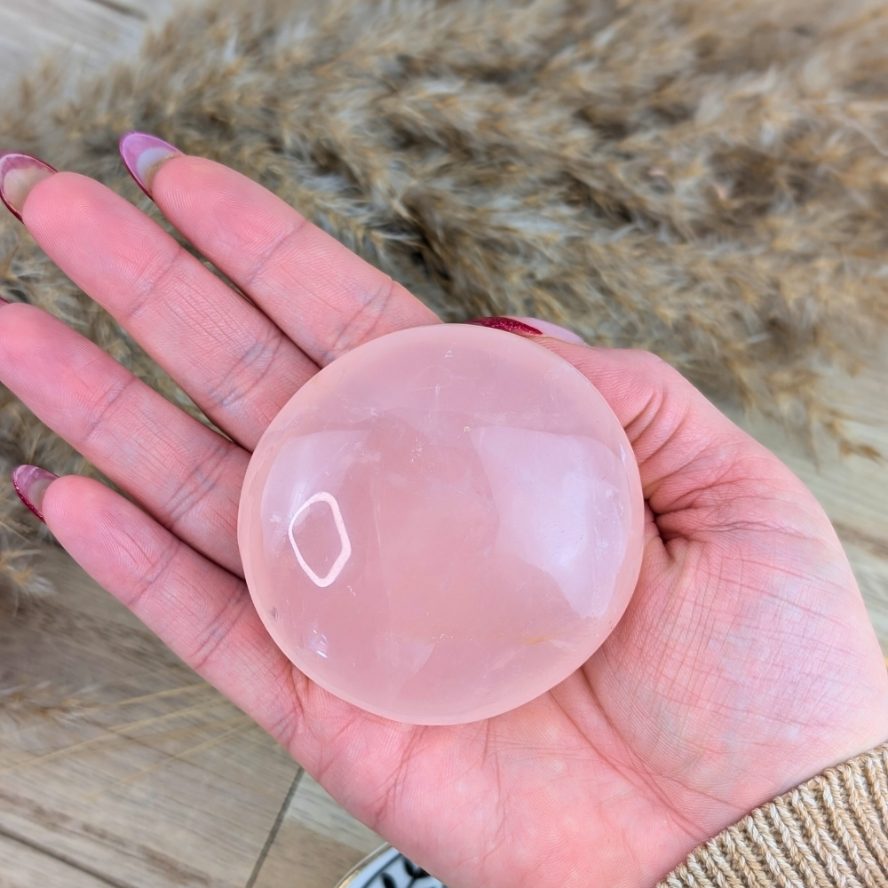 Round rose quartz palm stone for love and emotional clarity.