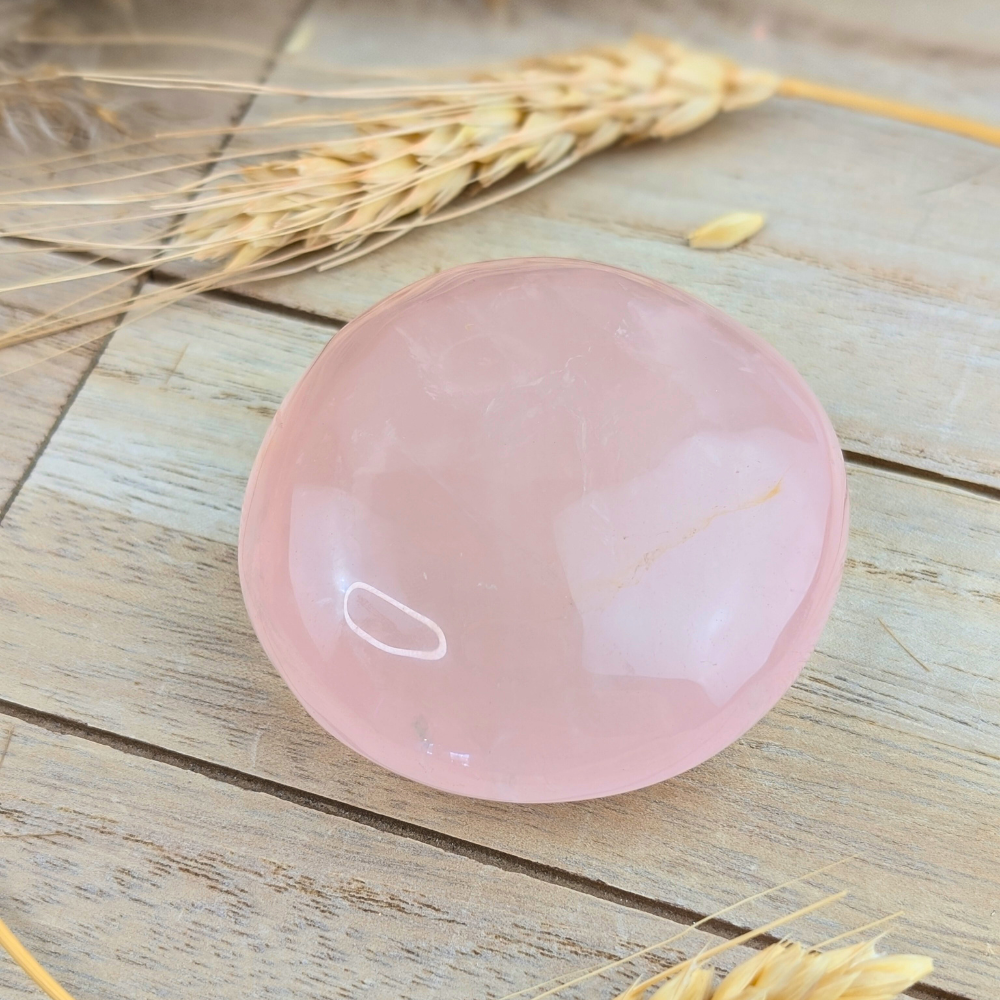 Polished rose quartz palm stone for energy healing and mindfulness.