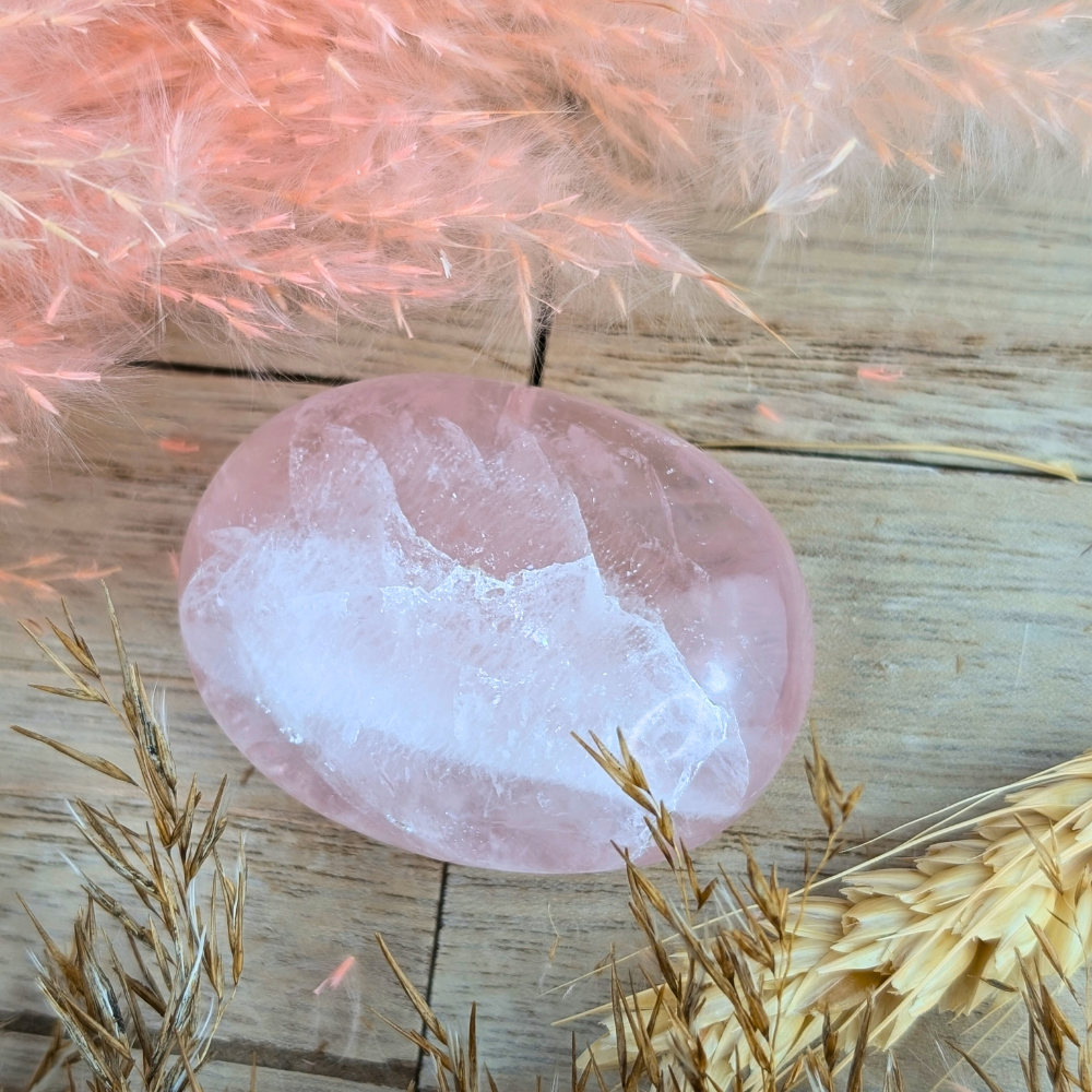 Rose Quartz Crystal Palm Stone with soft pink hues held in hand.