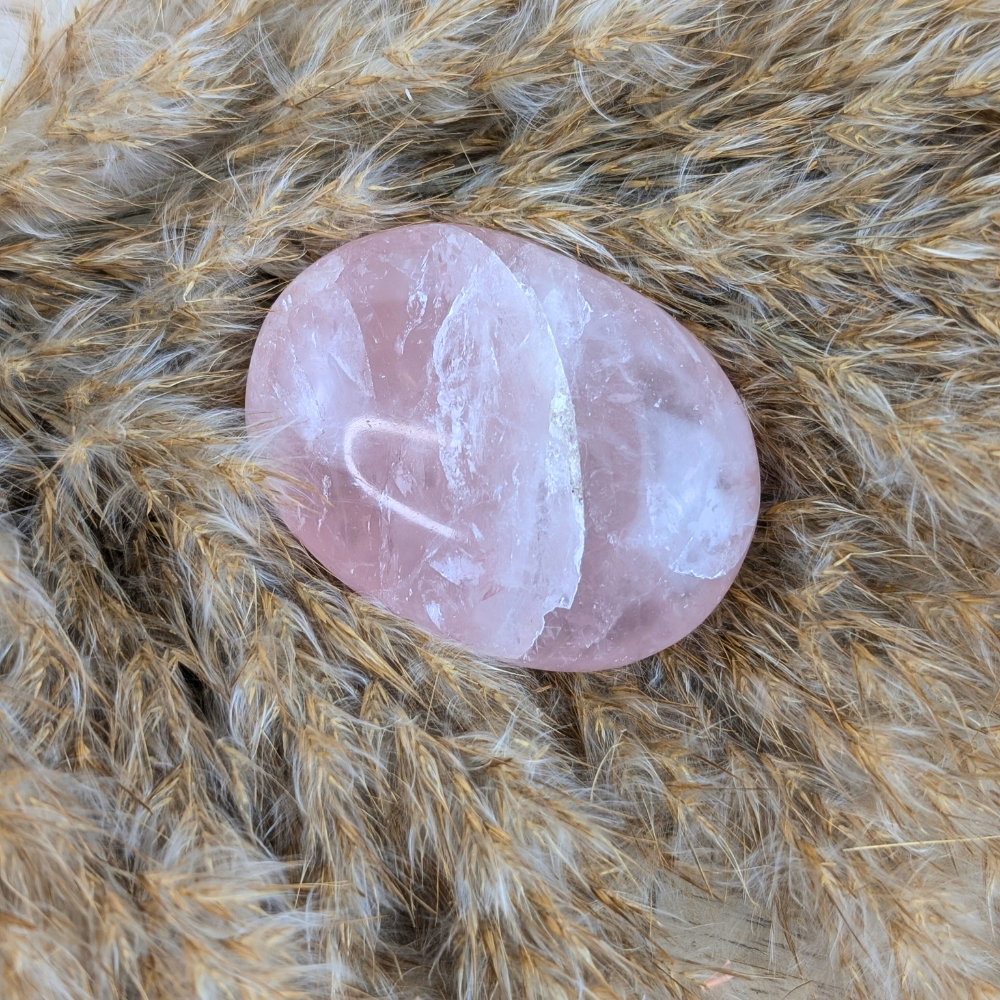 Rose quartz palm stone for energy healing and mindfulness practices.