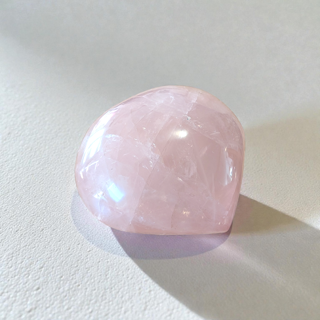 Soft pink rose quartz crystal heart for emotional healing and mindfulness.