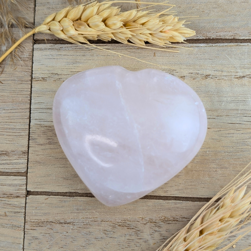 Soft pink rose quartz crystal heart for emotional healing and mindfulness.