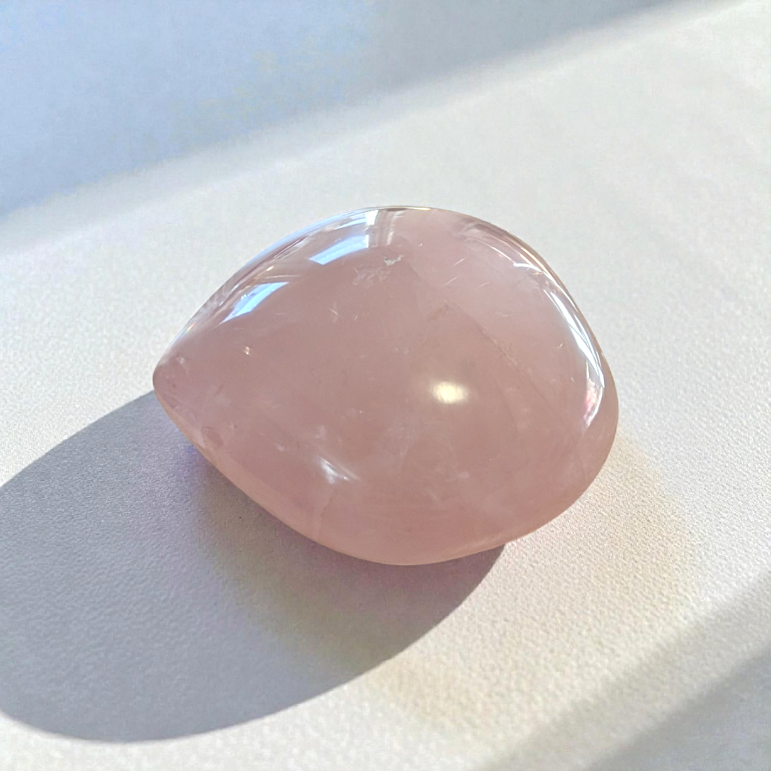Heart-shaped rose quartz crystal for balancing energy centers and self-care.