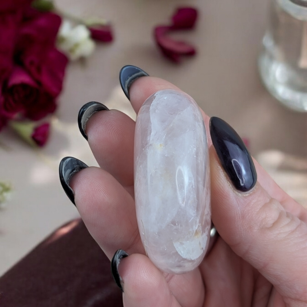 Rose Quartz Crystal for Love placed near delicate flowers.