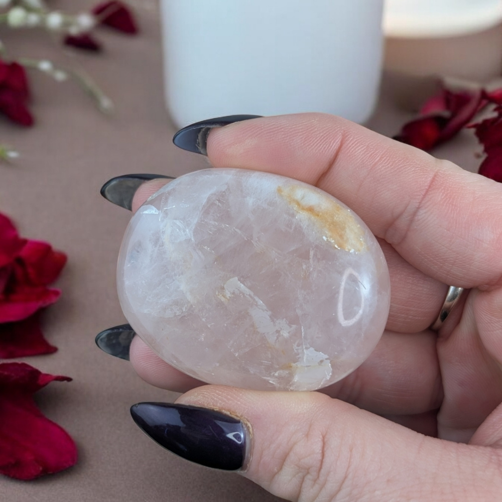 Polished Rose Quartz Crystal on a decorative table.