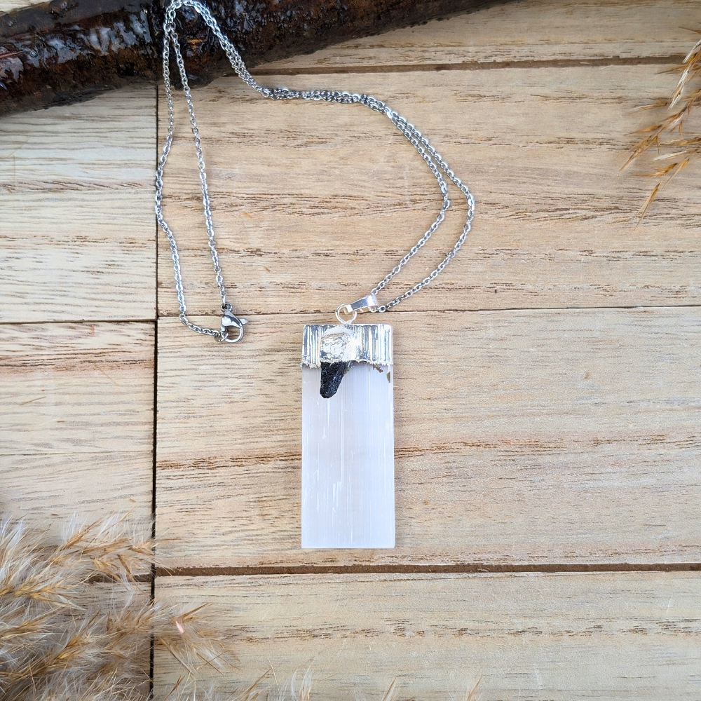 Close-up of Selenite and Black Tourmaline Necklace on a wooden background.