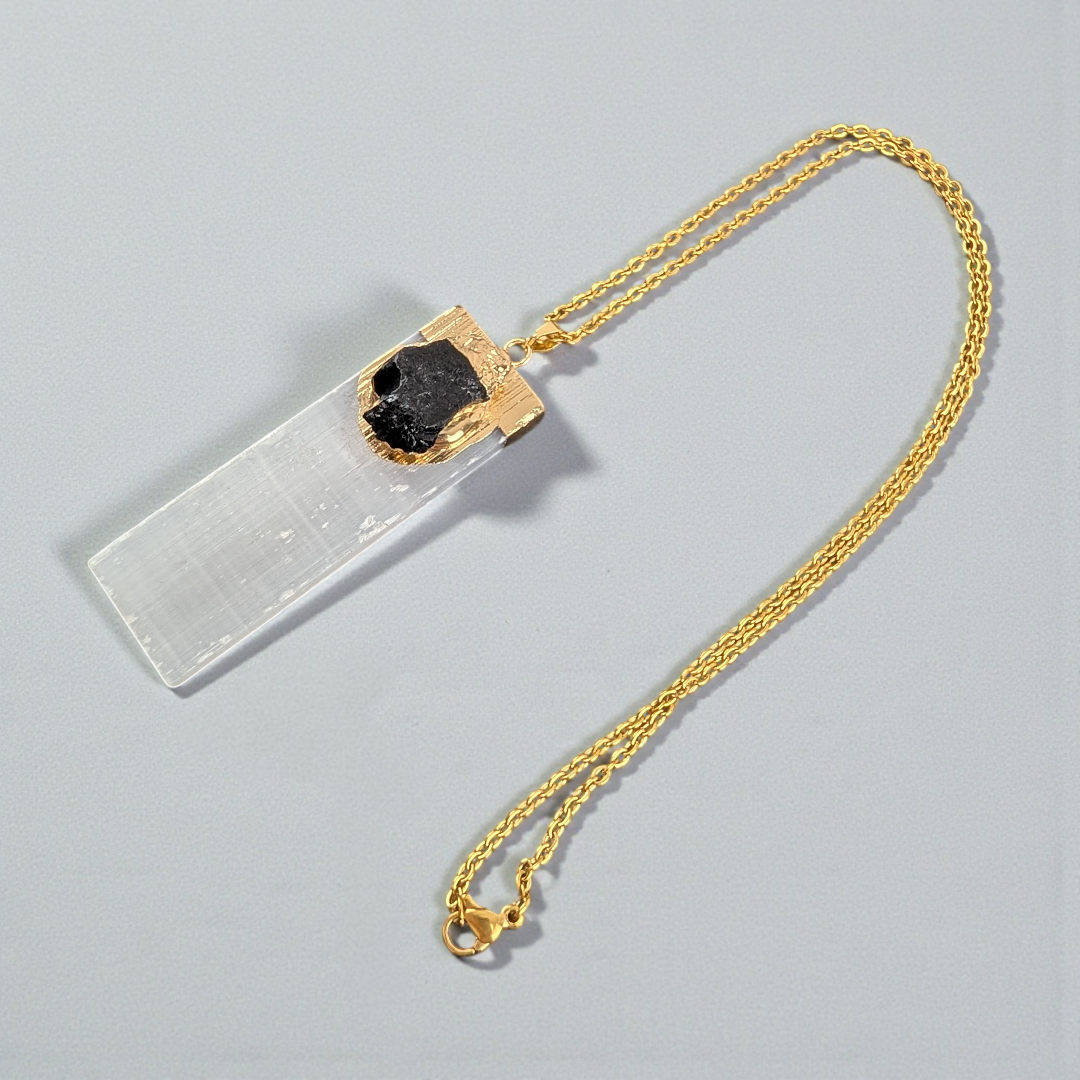 Selenite and Black Tourmaline Necklace styled on a natural wood surface