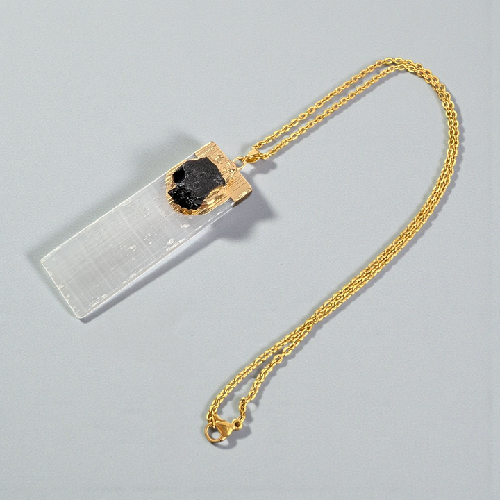 Selenite and Black Tourmaline Necklace styled on a natural wood surface