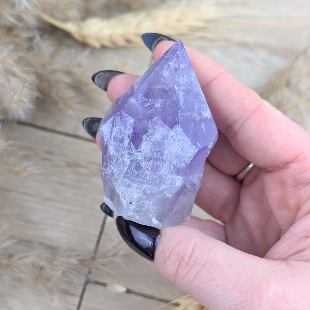 Small Amethyst Point crystal from Brazil on wood