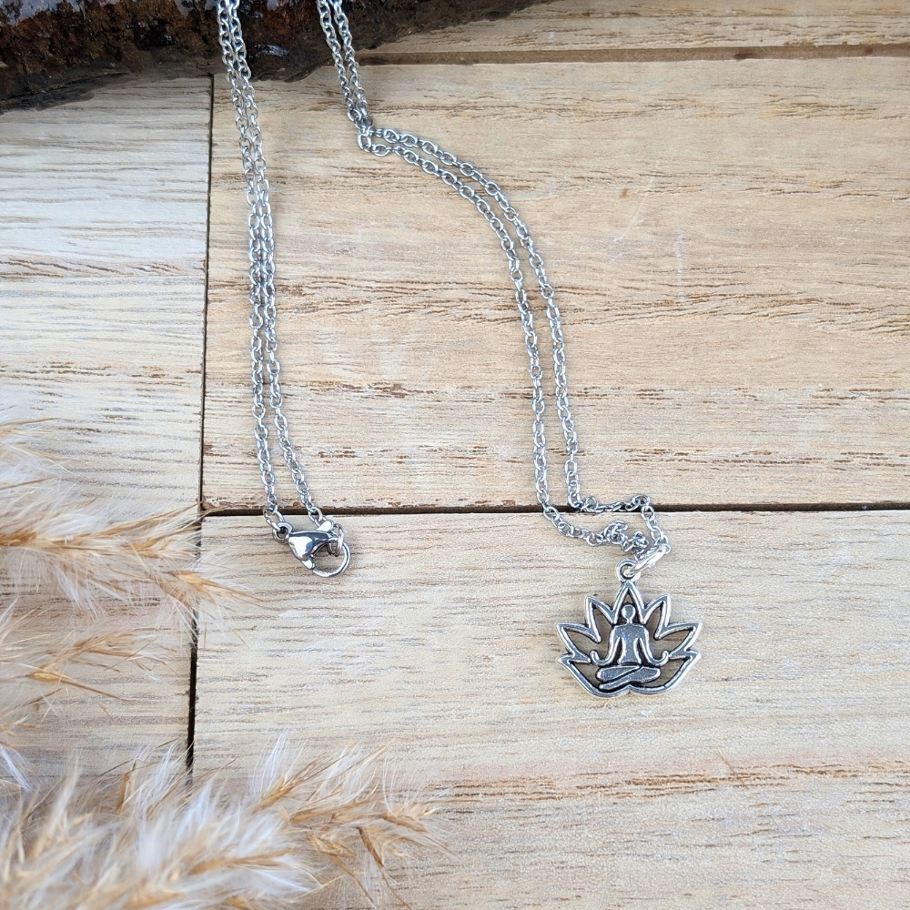 Close-up of the lotus flower pendant necklace displayed on a wooden surface