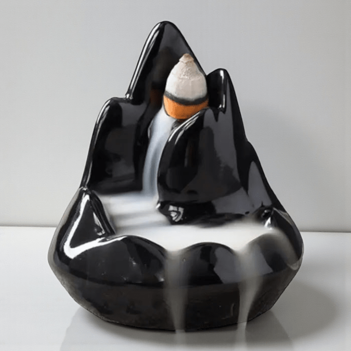Black ceramic incense holder with a small stack of incense on a white . background. Available at Zen Collection crystal store in Barrie. Shop instore or online.