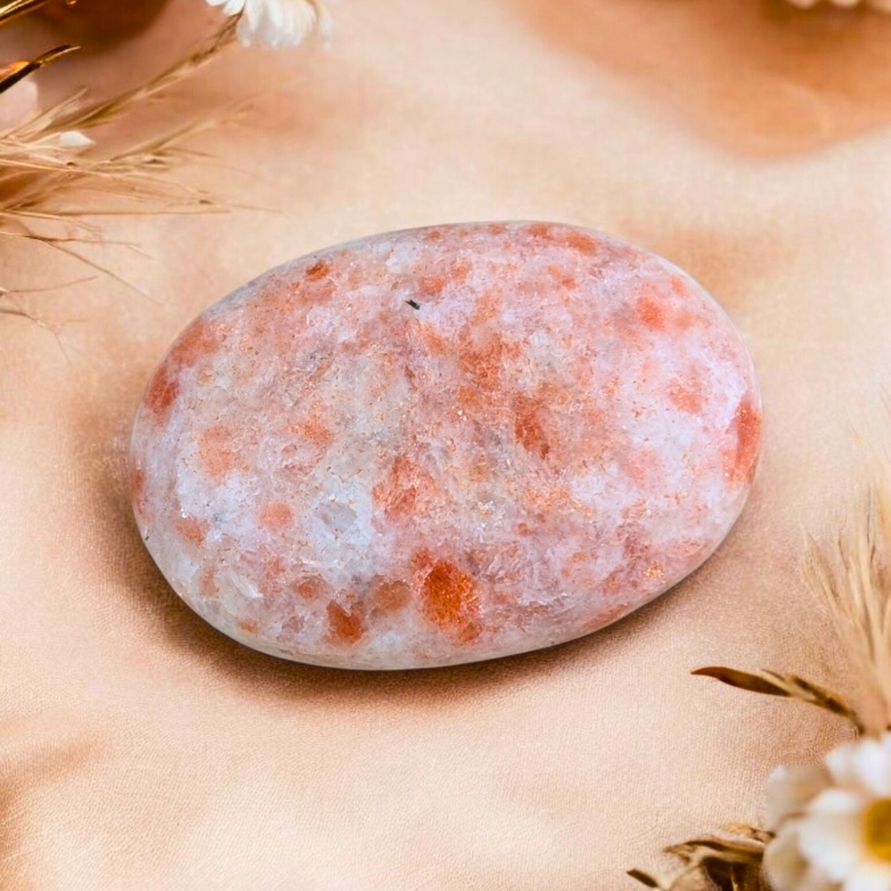 Polished sunstone palm stone showcasing reflective sparkles.