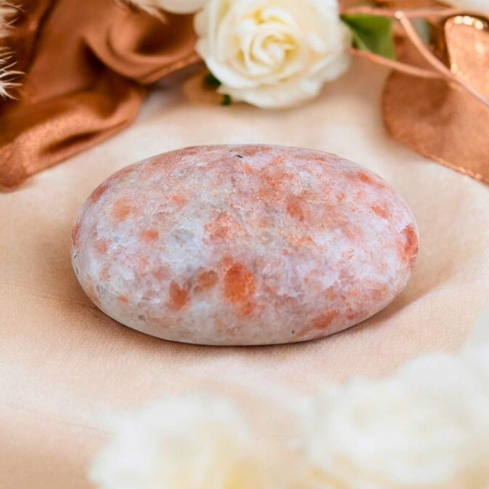 Smooth sunstone palm stone for meditation and energy work.