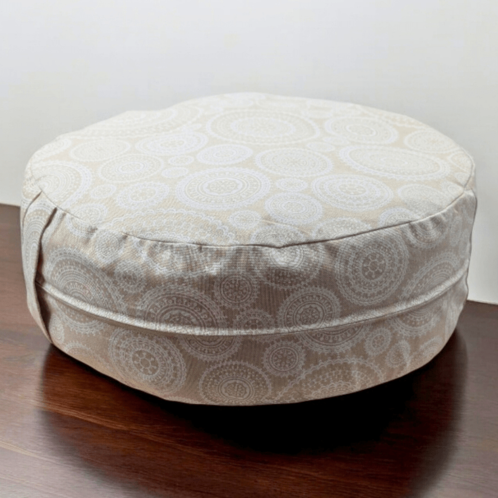 Meditation cushion with cotton cover on a wooden floor.