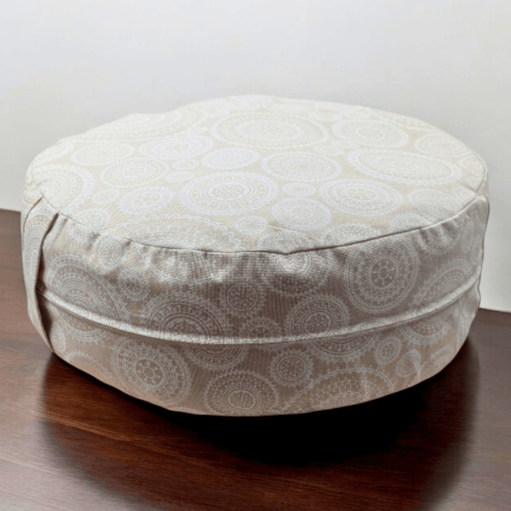 Meditation cushion with cotton cover on a wooden floor.