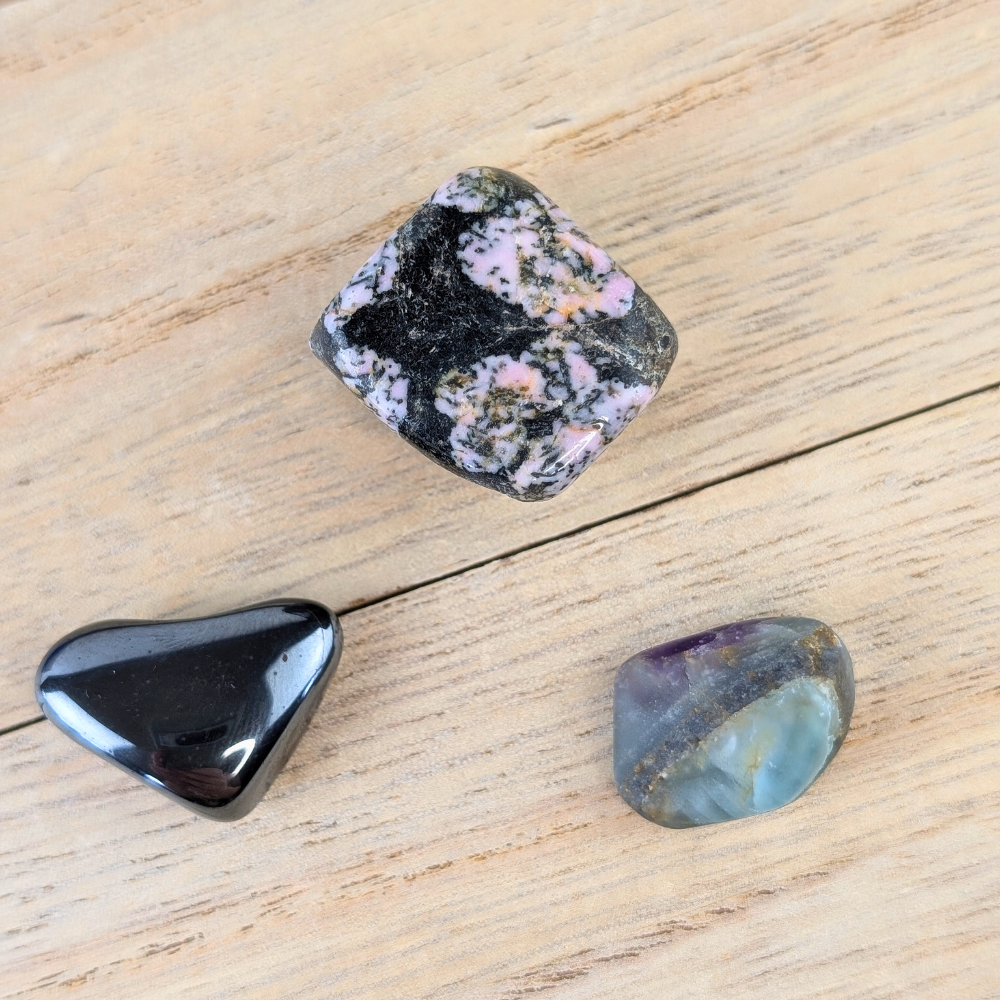 Snowflake Obsidian, Fluorite, and Hematite crystals with description cards.