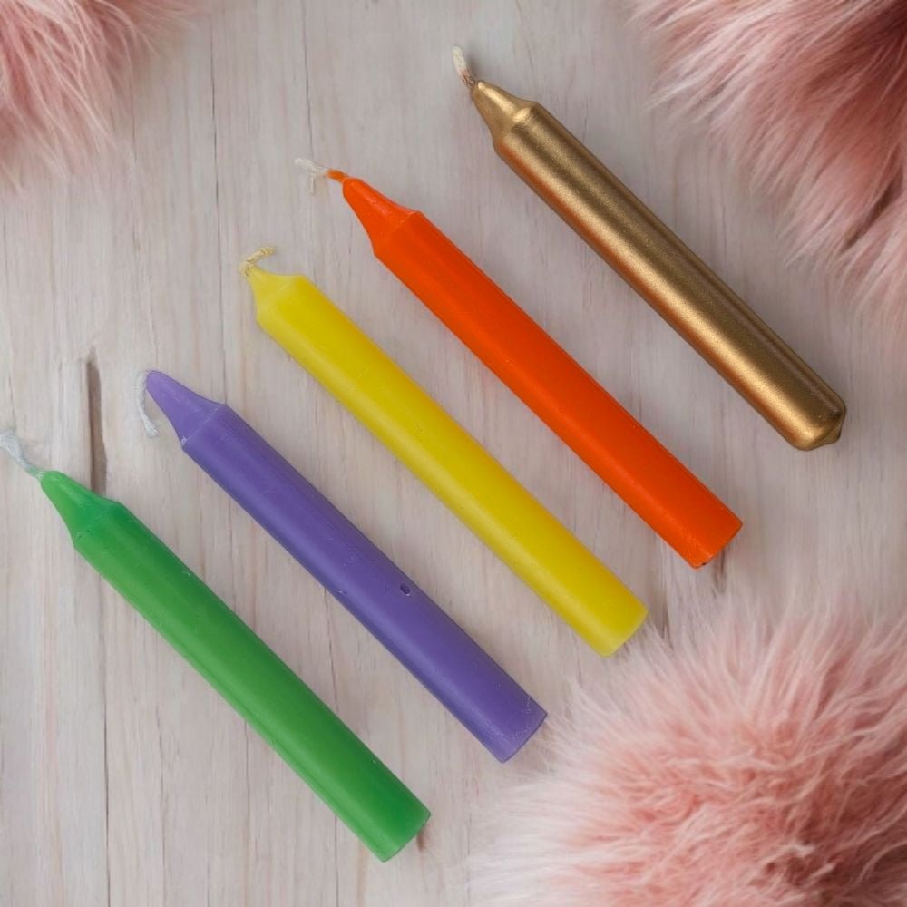 Colorful canadian metaphysical store inspiration candle set on a wooden surface with pink fur accents