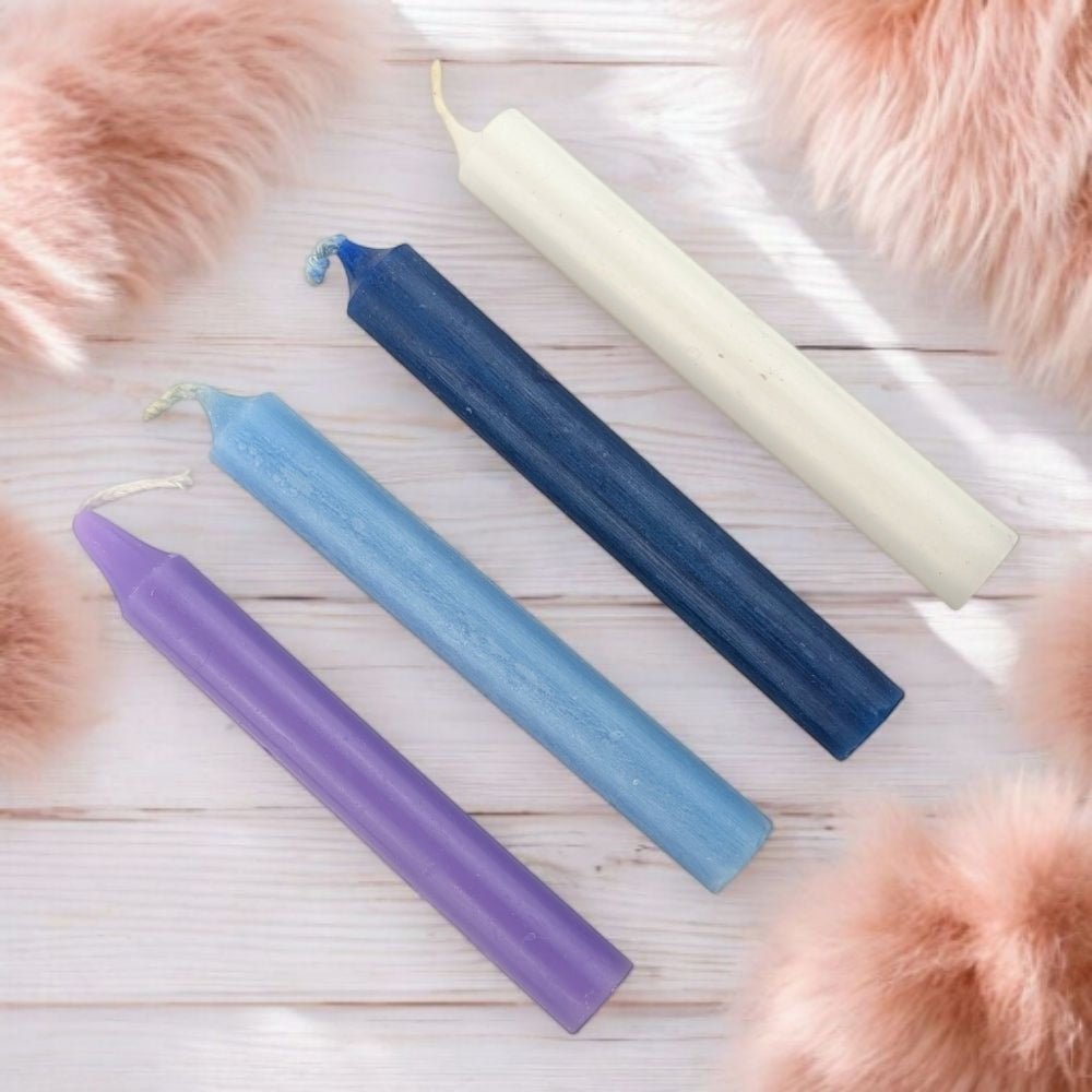 Four colored candles for spiritual wisdom on a wooden surface with pink fur around
