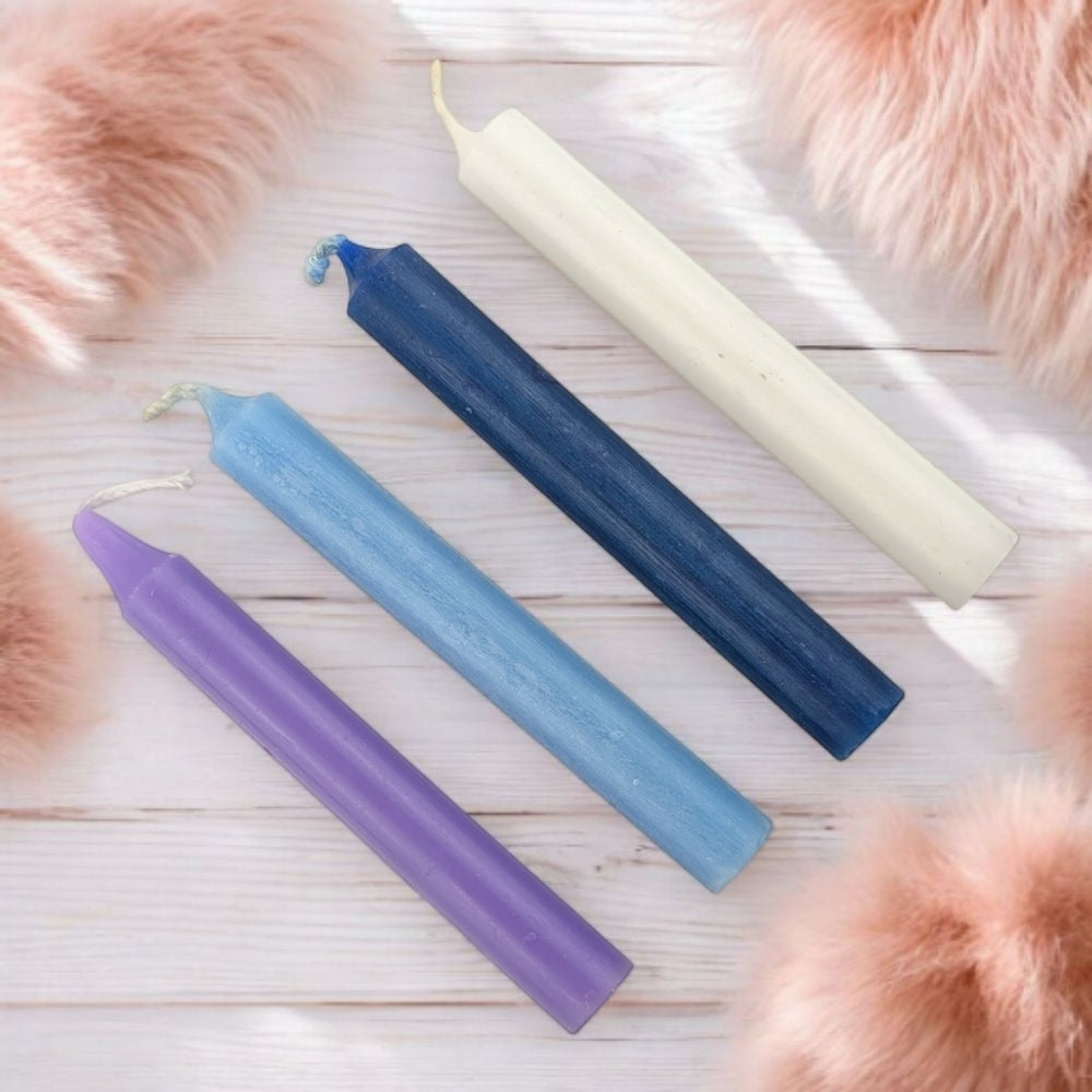 Four colored candles for spiritual wisdom on a wooden surface with pink fur around