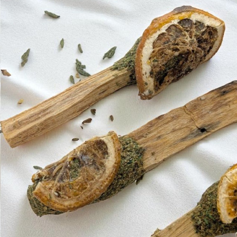 Dried orange slices and palo sticks on a white fabric background available at zen collection crystal store
