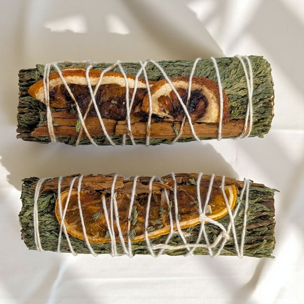 Two bundles of cedar and cinnamon sticks tied with twine on a white background available from zen collection crystal store