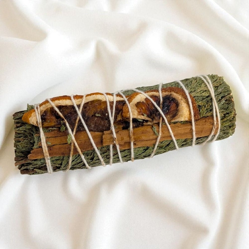 Rolled sage bundle with twine on a white fabric background available at zen collection crystal store in barrie ontario
