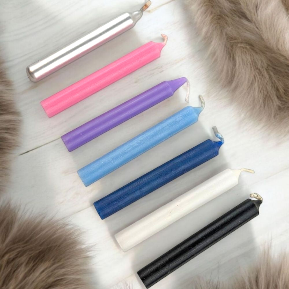Set of colorful chime candles for empaths on a fur surface