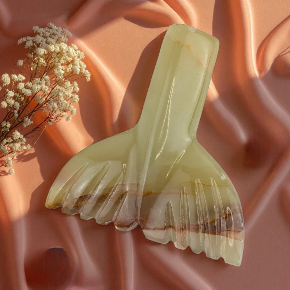 Decorative banded calcite piece with floral arrangement on a pink fabric background