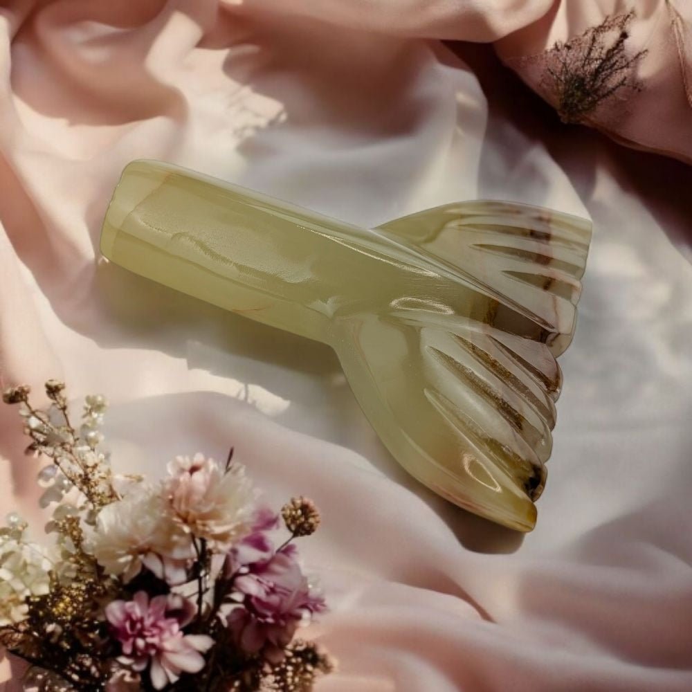 Decorative crystal mermaid tail design on a soft background with flowers