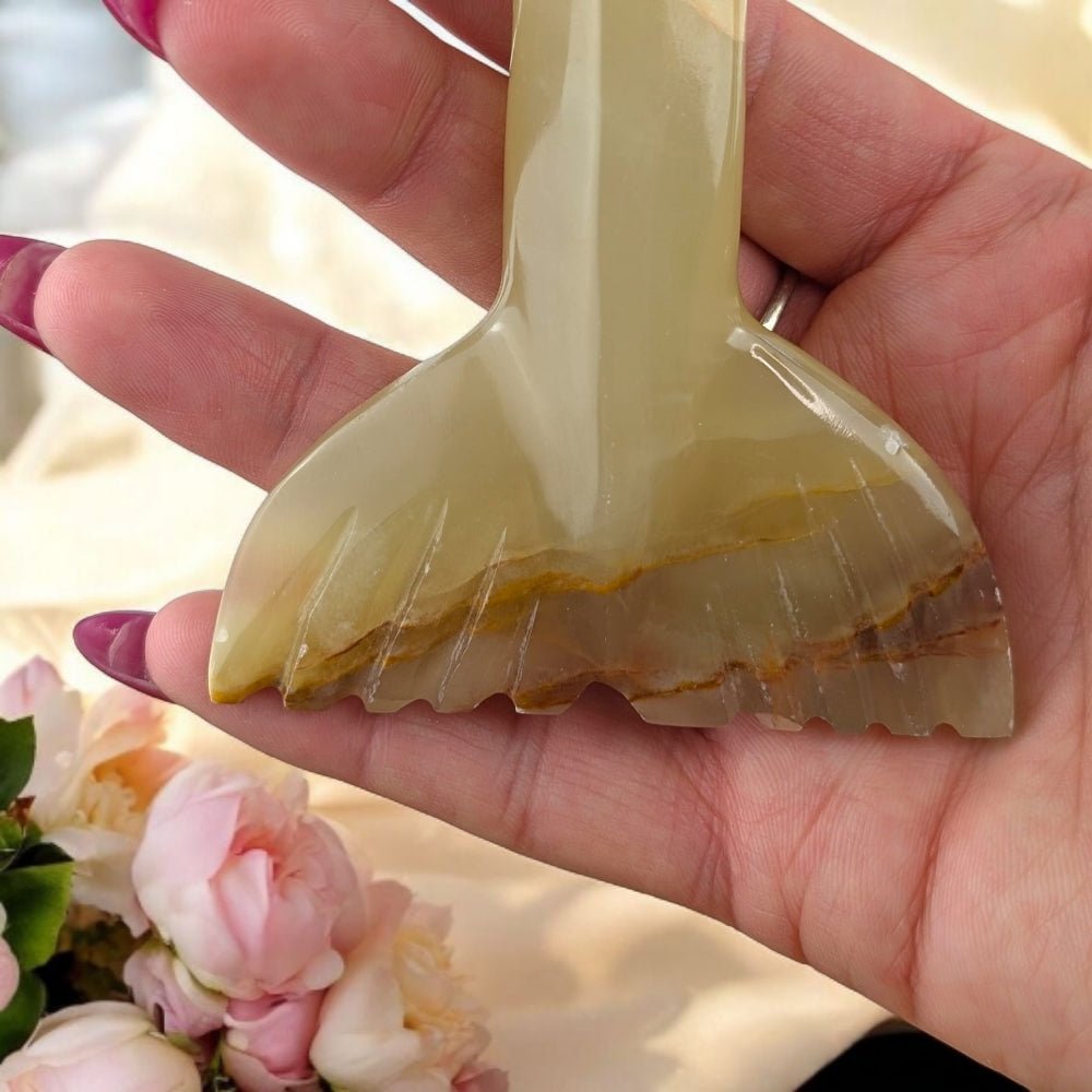 Hand holding a crystal with floral background