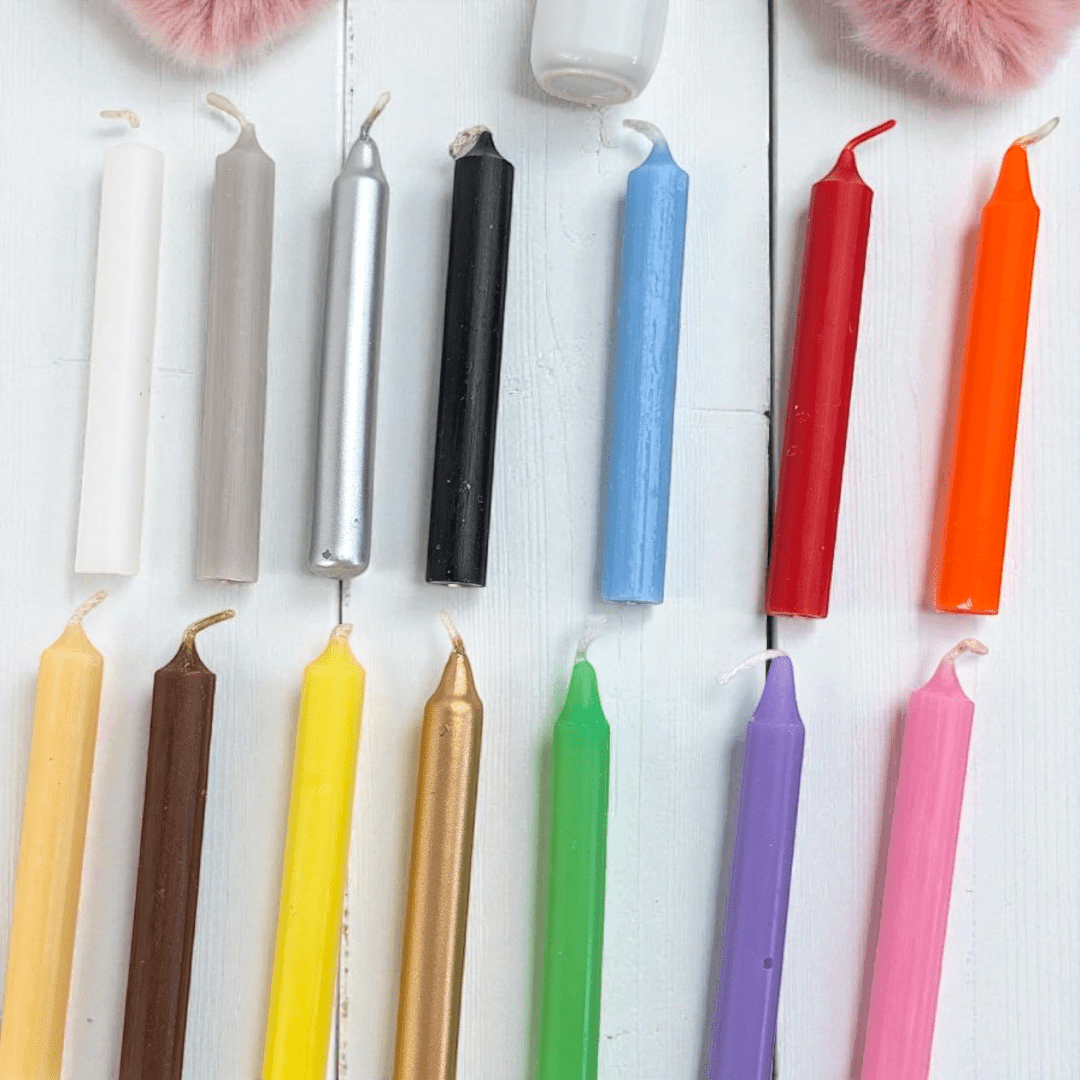 Colorful candles arranged in a row on a white surface. Spell candle kit available at zen collection crystal store in barrie