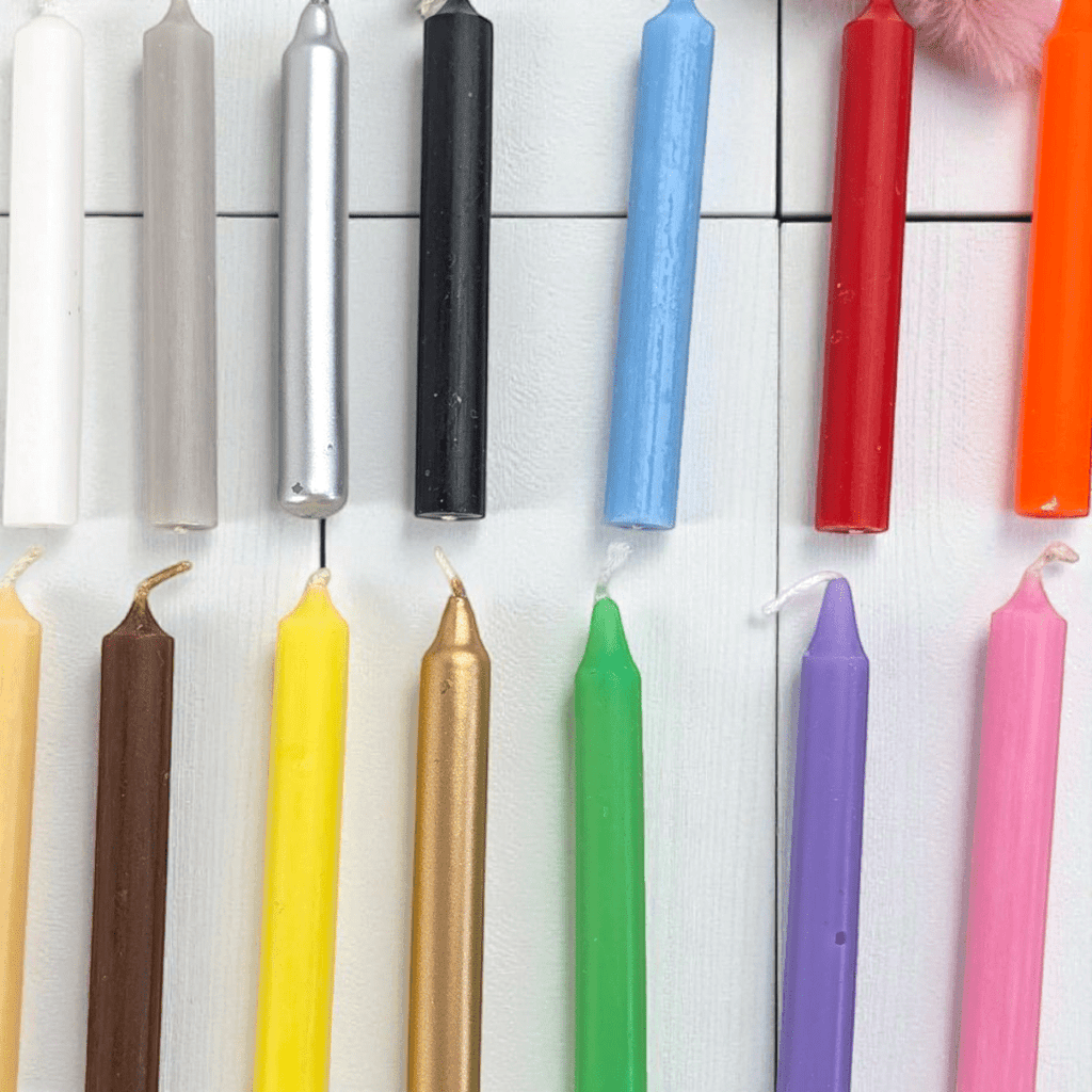 Assorted colorful candles on a white tiled background. Deluxe spell candle kit Available at zen collection crystal store in Barrie